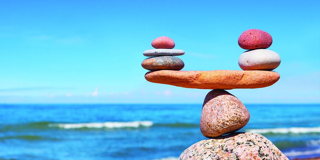 An image of rocks balancing on each other in front of the ocean